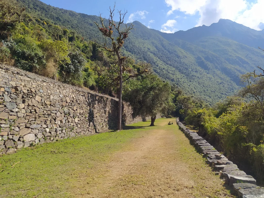 Muro de piedra y camino de pasto dentro del complejo de Choquequirao