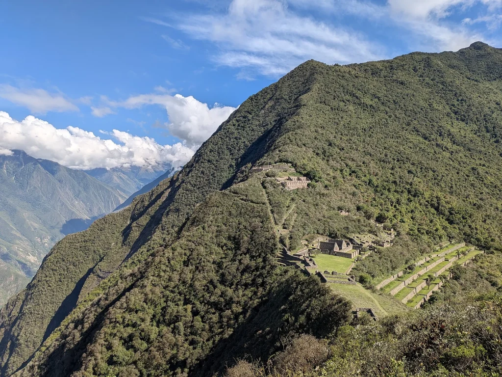 Vista de las ruinas de Choquequirao desde el camino, entre montañas verdes