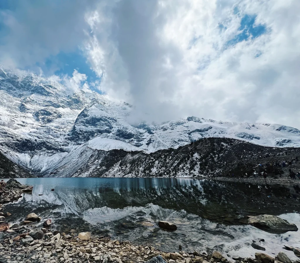 Orilla de la laguna Humantay con su reflejo y nubes sobre los glaciares