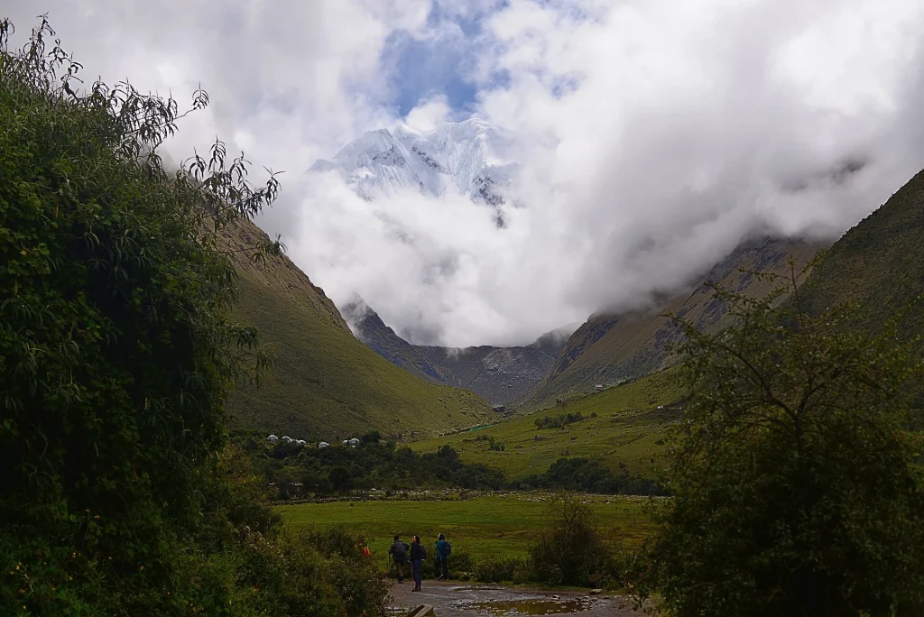 Valle verde con el nevado Salkantay entre las nubes