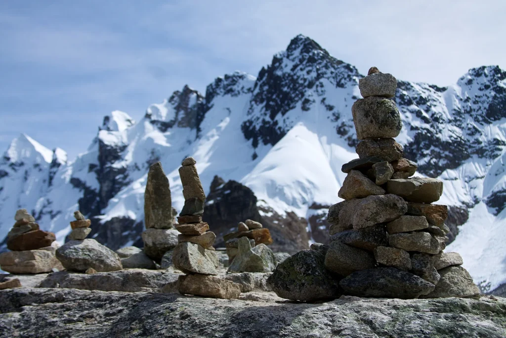 Apachetas de piedra en el paso Salkantay frente a montañas nevadas